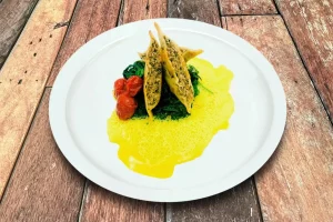 Handgemachte Maultaschen auf frischem Blattspinat, verfeinert mit Curryschaum.
