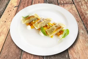 Handgemachte Maultaschen auf Kürbisragout mit Crème Fraîche. Ein herbstliches Genussgericht aus regionaler Küche.
