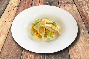 Handgemachte Maultaschen auf Kürbisragout mit feiner Beurre blanc.