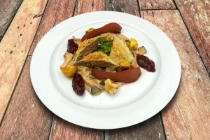 Handgemachte Wildmaultaschen auf Waldpilzragout, mit Rotweinbirne und glasierten Maronen